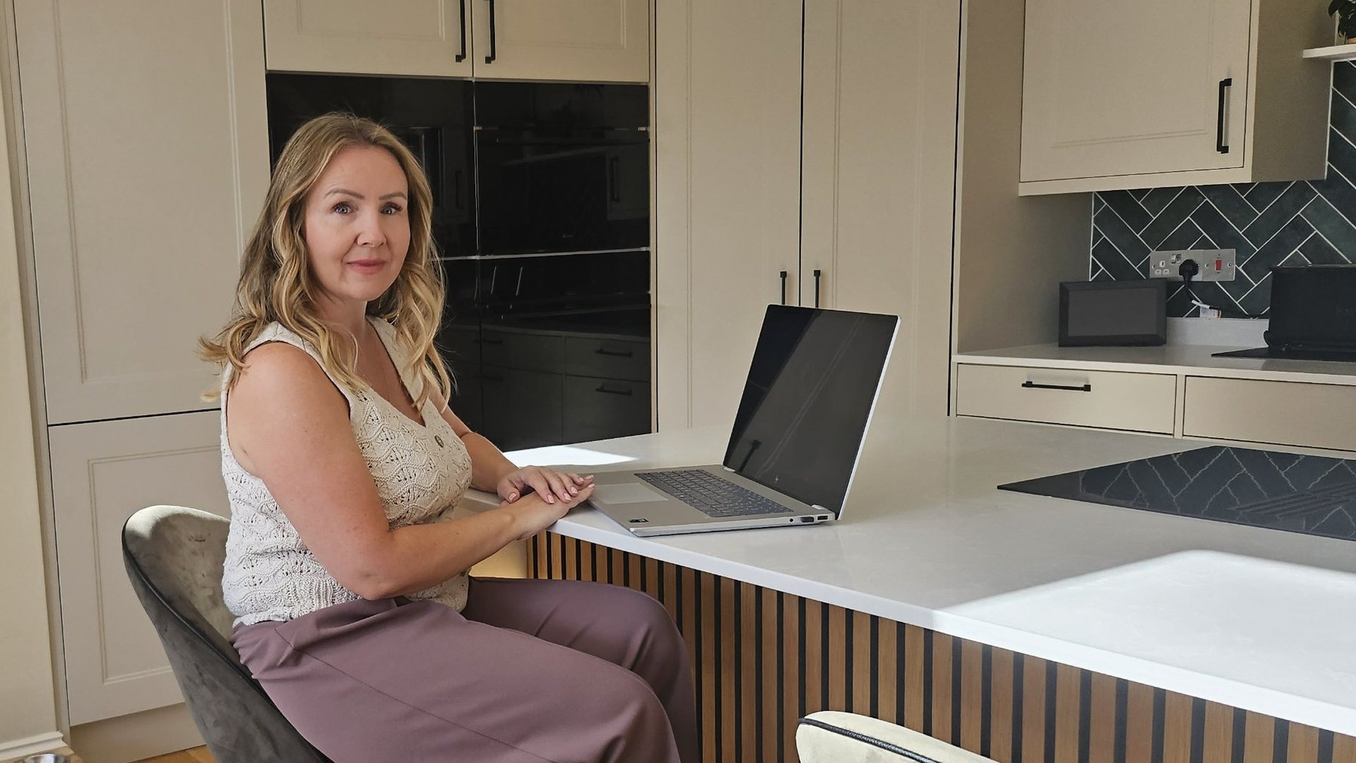 Lucy Goffin sitting at a kitchen island with her laptop.